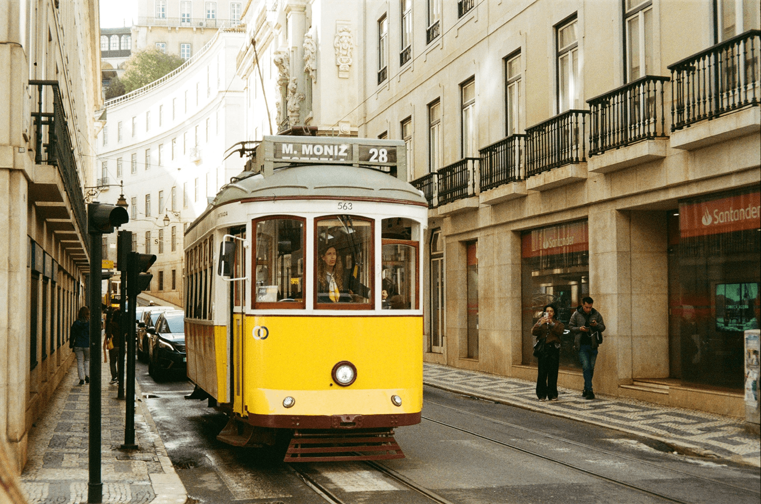 Yellow tram on a cobbled street