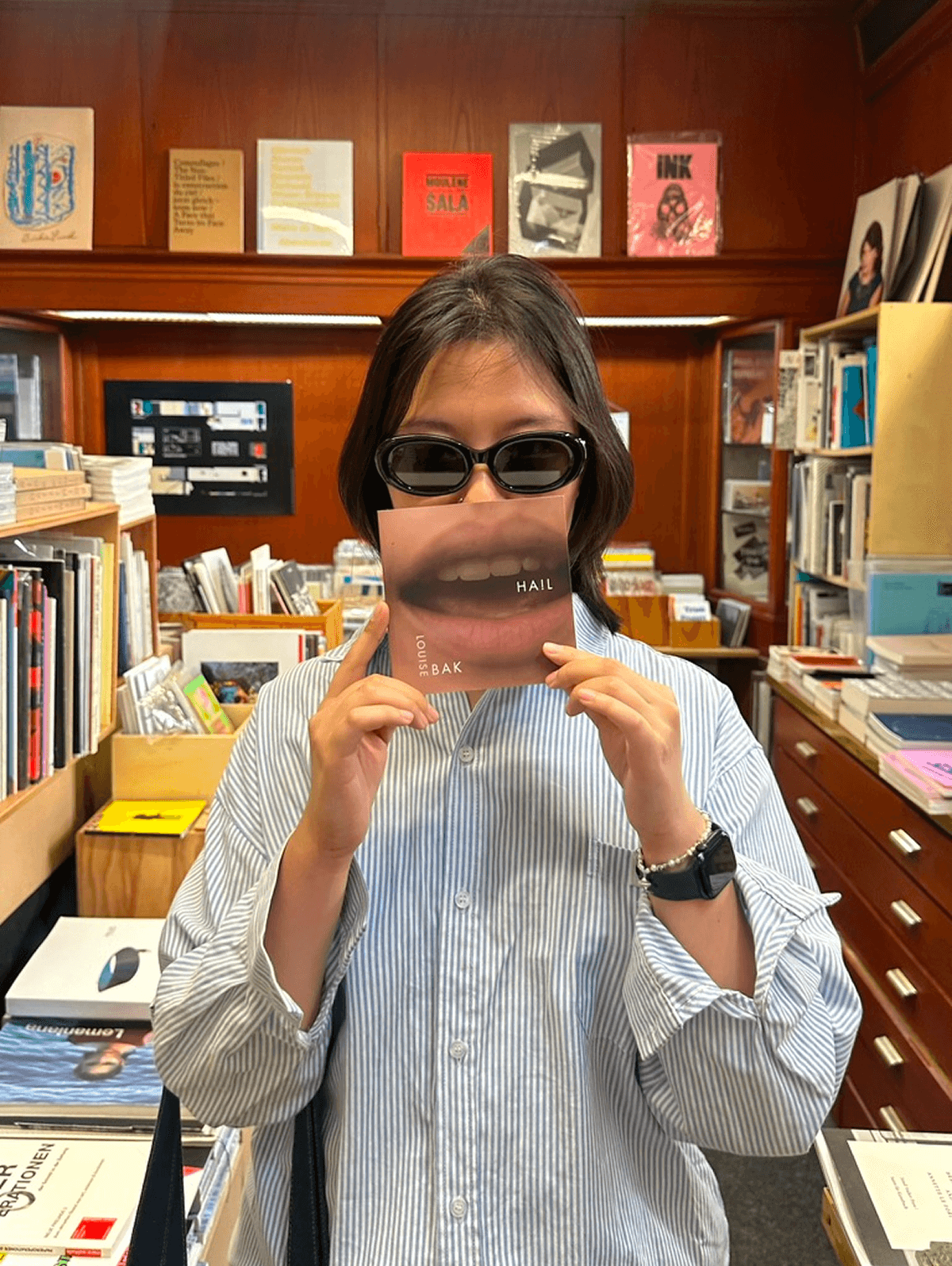Holding a lip postcard in a bookstore