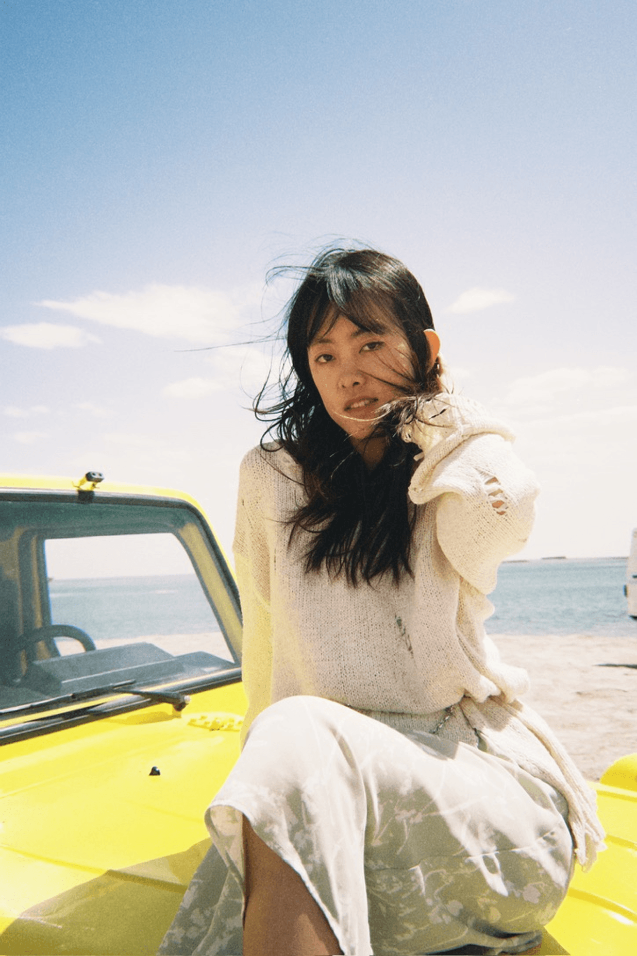 Portrait on a yellow car by the beach