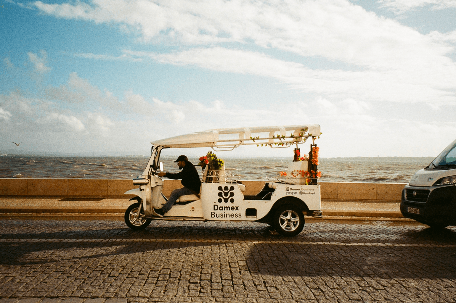 White tuk-tuk parked by the sea